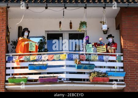 Sythen, Münsterland, NRW, 12th. Februar 2021. Eine Familie hat im kleinen Dorf Sythen bei Haltern-am-See in Nordrhein-Westfalen eine Szene mit gekleideten Shop-Dummies in Gesichtsmasken und positiven Ermutigungen zum "Bleiben optimistisch" auf ihrem Balkon inszeniert. Kredit: Imageplotter/Alamy Live Nachrichten Stockfoto