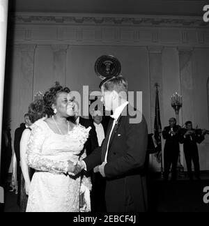 Abendessen zu Ehren von Vizepräsident Lyndon B. Johnson (LBJ), Sprecher des Hauses John W. McCormack, u0026 Chief Justice Earl Warren, 8:00pm Uhr. Präsident John F. Kennedy begrüßt Dr. Rosa Gragg, Präsidentin der National Association of Colored Womenu0027s Clubs, bei einem Abendessen zu Ehren von Vizepräsident Lyndon B. Johnson, dem Sprecher des Repräsentantenhauses John W. McCormack und dem Obersten Gerichtshof Earl Warren. Der stellvertretende Generalstaatsanwalt Byron White (teilweise versteckt, über der Schulter von Dr. Graggu0027s) und der Kongressabgeordnete Hale Boggs aus Louisiana (gegenüber der Kamera) stehen im Hintergrund; Musikerin Stockfoto