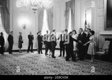 Diplomatischer Empfang, 6:00pm Uhr. Präsident John F. Kennedy, First Lady Jacqueline Kennedy und andere begrüßen die Gäste in der Empfangsleitung bei einem diplomatischen Empfang im Weißen Haus. Von links nach rechts: Neun nicht identifizierte Personen; Protokollchef, Angier Biddle Duke; Präsident Kennedy; nicht identifizierter Mann; Mrs. Kennedy; Militärhilfe an den Präsidenten, General Chester V. Clifton (hinten, teilweise versteckt); Vizepräsident Lyndon B. Johnson; Marinehafter an den Präsidenten, Kapitän Tazewell Shepard; Lady Bird Johnson. State Dining Room, White House, Washington, D.C. Stockfoto