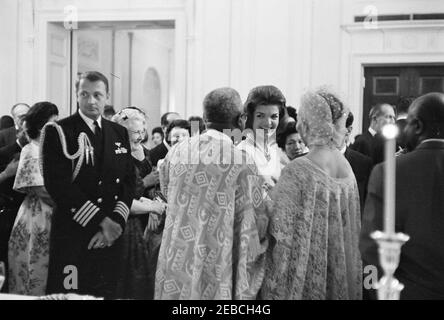 Diplomatischer Empfang, 6:00pm Uhr. First Lady Jacqueline Kennedy (rechts) Besuche mit Gästen im East Room während eines diplomatischen Empfangs im Weißen Haus, Washington, D.C. Naval Aide to the President, Captain Tazewell Shepard, steht auf der linken Seite; alle anderen sind nicht identifiziert. Stockfoto