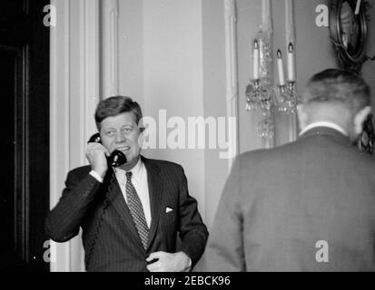 Präsident Kennedy sieht den Start des US-bemannten Orbital-Fluges von 1st. Präsident John F. Kennedy spricht am Telefon, nachdem er die Fernsehberichterstattung des Astronauten Oberstleutnants John H. Glenn, Jr. UG 0027, beim ersten bemannten Orbitalflug von Cape Canaveral, Florida, an Bord von Mercury-Atlas 6 (auch bekannt als Friendship 7) beobachtet hatte. Vice President Lyndon B. Johnson, mit dem Rücken zur Kamera, steht auf der rechten Seite. Familien-Esszimmer, White House, Washington, D.C. Stockfoto