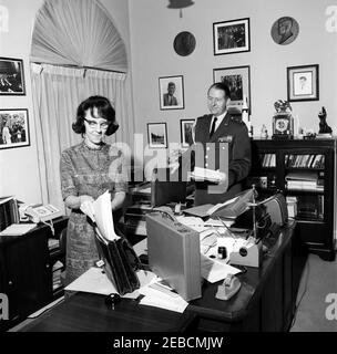 Mitarbeiter des Weißen Hauses: Militärhilfe für den Präsidenten Gen. Chester V. Clifton, nationaler Sicherheitsberater McGeorge Bundy, Präsidialsekretärin Evelyn Lincoln. Persönliche Sekretärin des Präsidenten John F. Kennedy Evelyn Lincoln (links) legt Aktenordner in den schwarzen Alligator-Aktenkoffer des Präsidenten Kennedyu0027s; Militärhilfe an den Präsidenten General Chester V. Clifton, der Dokumente hält, schaut von rechts. Büro Presidentu2019s Secretaryu2019s, Weißes Haus, Washington, D.C. Stockfoto