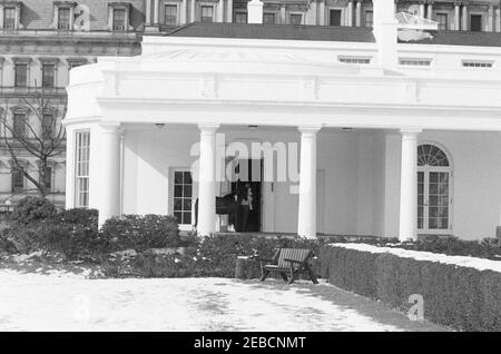 First Lady Jacqueline Kennedyu0027s (JBK) Schlittenfahrt auf dem South Lawn. First Lady Jacqueline Kennedy, die ihren Sohn John F. Kennedy, Jr. hält, steht in der Tür des Oval Office, mit Caroline Kennedyu0027s Pony Macaroni im Schlepptau. West Wing Colonnade, White House, Washington, D.C. Stockfoto