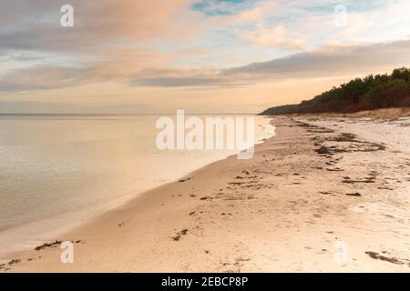 Wunderschöne Meereslandschaft am dramatischen bewölkten Himmel bei Sonnenuntergang. Ruhige Abendlandschaft. Natur Hintergrund des ruhigen Meerwassers und Sandstrand. Sommertrave Stockfoto