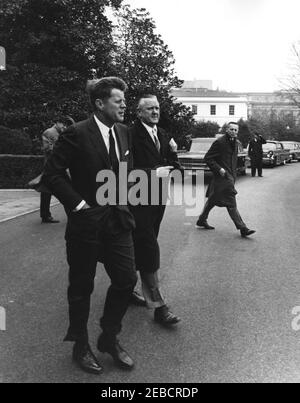 Begrüßungszeremonie nach der Rückkehr der US-Delegation zur Konferenz von Punta del Este, 2:10pm Uhr. Präsident John F. Kennedy geht mit einem unbekannten Mann, nachdem er Delegierte bei ihrer Rückkehr von der Konferenz von Punta del Este in Uruguay begrüßt hat. Geheimagentin Ernie Olsson läuft rechts. South Lawn, White House, Washington, D.C. Stockfoto