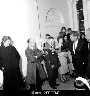 Empfang für Astronaut John Herschel Glenn, Jr., 11:55am Uhr. Präsident John F. Kennedy (rechts, gestikulierend zu unidentifiziertem U.S. Army Sergeant, Klasse 1st) und Astronaut Oberstleutnant John H. Glenn, Jr. (teilweise versteckt am rechten Bildrand) begrüßen unidentifizierte Gäste bei einem Empfang zu Ehren Oberstleutnant Glenn. Eingang North Portico, White House, Washington, D.C. Stockfoto