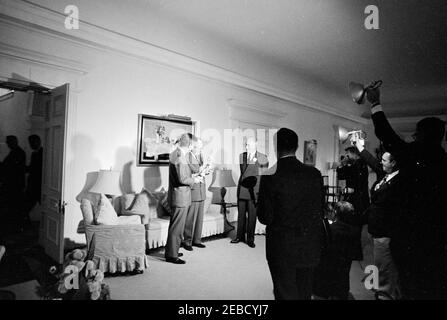 Reise nach Bermuda: Generalmajor Sir Julian Gascoigne, Gouverneur von Bermuda, überreicht Geschenke an Präsident Kennedy und Harold Macmillan, Premierminister von Großbritannien, im Government House, Hamilton, Bermuda. Pressevertreter beobachten, wie Präsident John F. Kennedy und Premierminister von Großbritannien Harold Macmillan (Mitte) Porzellanfiguren vom Gouverneur von Bermuda, Generalmajor Sir Julian Gascoigne (rechts), im Government House in Hamilton, Bermuda, erhalten. President Kennedyu2019s Figur zeigt einen spanischen Hog-Fisch und einen Sergeant Major Fisch, der um ein Stück Koralle schwimmt; ein silberpla Stockfoto