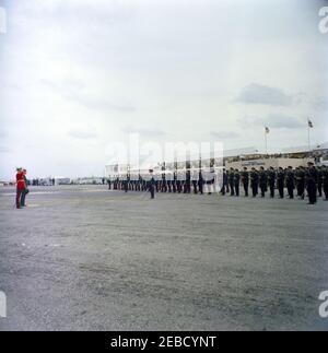 Reise nach Bermuda: Ankunft auf der Kindley Air Force Base, Bermuda, 12:55pm Uhr. Präsident John F. Kennedy (links, mit Hut) inspiziert Truppen bei seiner Ankunft in Bermuda von Palm Beach, Florida. Gouverneur von Bermuda Major General Sir Julian Gascoigne steht auf der linken Seite (neben Präsident Kennedy, trägt roten Mantel). Kindley Air Force Base, St. Davidu2019s Island, Bermuda. Stockfoto