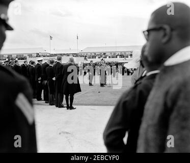 Reise nach Bermuda: Ankunft auf der Kindley Air Force Base, Bermuda, 12:55pm Uhr. Premierminister von Großbritannien Harold Macmillan (in der Mitte, vor Mikrofonen stehend) spricht die Menge über Präsident John F. Kennedyu2019s Ankunft in Bermuda von Palm Beach, Florida. Präsident Kennedy und der Gouverneur von Bermuda, Generalmajor Sir Julian Gascoigne (meist versteckt), stehen hinter Premierminister Macmillan. Kindley Air Force Base, St. Davidu2019s Island, Bermuda. [Foto von Dan Lewis] Stockfoto