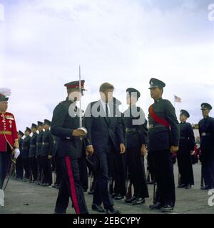 Reise nach Bermuda: Ankunft auf der Kindley Air Force Base, Bermuda, 12:55pm Uhr. Präsident John F. Kennedy (mit Hut) inspiziert Truppen bei seiner Ankunft in Bermuda von Palm Beach, Florida. Gouverneur von Bermuda Major General Sir Julian Gascoigne geht nach links (mit rotem Mantel). Kindley Air Force Base, St. Davidu2019s Island, Bermuda. Stockfoto