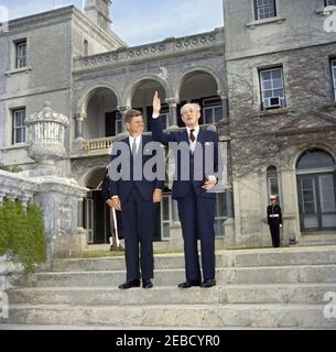 Ausflug nach Bermuda: Baumpflanzung im Government House, Hamilton, Bermuda. Präsident John F. Kennedy lacht als Premierminister von Großbritannien Harold Macmillan mit der Hand auf die Schritte des Regierungshauses in Hamilton, Bermuda. Stockfoto