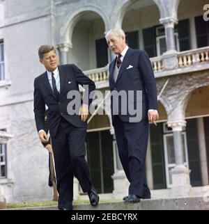 Ausflug nach Bermuda: Baumpflanzung im Government House, Hamilton, Bermuda. Präsident John F. Kennedy und Premierminister von Großbritannien Harold Macmillan gehen die Stufen des Regierungshauses in Hamilton, Bermuda hinunter. Stockfoto