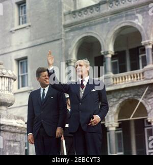 Ausflug nach Bermuda: Baumpflanzung im Government House, Hamilton, Bermuda. Präsident John F. Kennedy lacht als Premierminister von Großbritannien Harold Macmillan mit der Hand auf die Schritte des Regierungshauses in Hamilton, Bermuda. Stockfoto