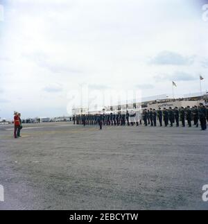 Reise nach Bermuda: Ankunft auf der Kindley Air Force Base, Bermuda, 12:55pm Uhr. Präsident John F. Kennedy (links, mit Hut) inspiziert Truppen bei seiner Ankunft in Bermuda von Palm Beach, Florida. Gouverneur von Bermuda Major General Sir Julian Gascoigne steht auf der linken Seite (neben Präsident Kennedy, trägt roten Mantel). Kindley Air Force Base, St. Davidu2019s Island, Bermuda. Stockfoto