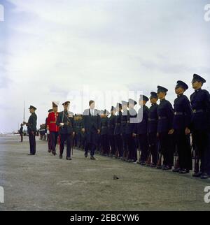 Reise nach Bermuda: Ankunft auf der Kindley Air Force Base, Bermuda, 12:55pm Uhr. Präsident John F. Kennedy (mit Hut) inspiziert Truppen bei seiner Ankunft in Bermuda von Palm Beach, Florida. Gouverneur von Bermuda Major General Sir Julian Gascoigne geht nach links (mit rotem Mantel). Kindley Air Force Base, St. Davidu2019s Island, Bermuda. Stockfoto