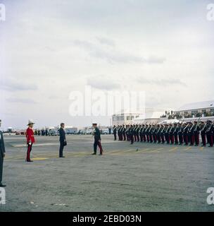 Reise nach Bermuda: Ankunft auf der Kindley Air Force Base, Bermuda, 12:55pm Uhr. Präsident John F. Kennedy (mit Hut) inspiziert Truppen bei seiner Ankunft in Bermuda von Palm Beach, Florida. Der Gouverneur von Bermuda, General Sir Julian Gascoigne, steht auf der linken Seite (mit rotem Mantel). Kindley Air Force Base, St. Davidu2019s Island, Bermuda. Stockfoto