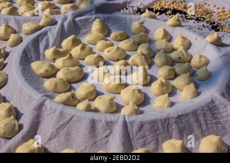 Bengalische sonnengetrocknete Knödel oder bori aus roter Linse und schwarzem Gramm auf weißem Tuch zum Trocknen gehalten. Wunderschön dekoriertes Foto zeigt lokale bengalen Stockfoto