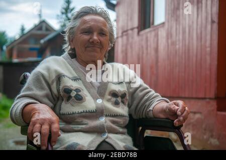 05-16-2018. Lomnicka, Slowakei. Roma oder Zigeuner alte Frau auf einem Rollstuhl in einer verlassenen Gemeinschaft im Herzen der Slowakei, leben in miserable condit Stockfoto