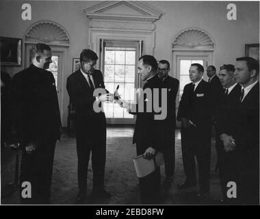 Übergabe der Laetare-Medaille Notre Dameu0027s an Präsident Kennedy, 1:25pm Uhr. Präsident John F. Kennedy wird von der University of Notre Dame die Laetare-Medaille für 1961 verliehen. Teilnahme an der Präsentation (L-R): Pater Edmund P. Joyce, Vizepräsident der University of Notre Dame; Präsident Kennedy; Reverend Theodore M. Hesburgh, Präsident der University of Notre Dame; drei unbekannte Männer; und Vertreter John Brademas (Indiana). Nicht identifizierter Mann im Hintergrund. Oval Office, White House, Washington, D.C. Stockfoto