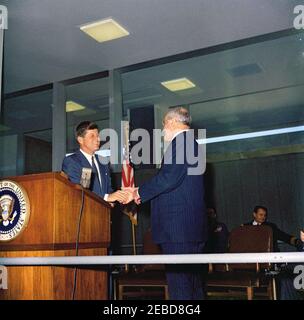 Übergabe der National Security Medal an Allen Dulles, 11:00am Uhr. Präsident John F. Kennedy schüttelt die Hände mit Allen W. Dulles, dem scheidenden Direktor der Central Intelligence Agency (CIA), nachdem er ihm die National Security Medal überreicht hatte. Im Hintergrund sitzen Air Force Aide dem Präsidenten Brigadier General Godfrey T. McHugh (teilweise versteckt) und Naval Aide dem Präsidenten Captain Tazewell Shepard. CIA-Hauptquartier, Langley, Virginia. Stockfoto