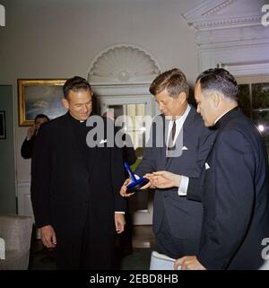 Übergabe der Laetare-Medaille Notre Dameu0027s an Präsident Kennedy, 1:25pm Uhr. Präsident John F. Kennedy wird von der University of Notre Dame die Laetare-Medaille für 1961 verliehen. (L-R) Pater Edmund P. Joyce, Vizepräsident der University of Notre Dame; Präsident Kennedy; Reverend Theodore M. Hesburgh, Präsident der University of Notre Dame. Oval Office, White House, Washington, D.C. Stockfoto