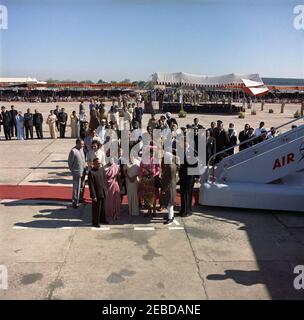 First Lady Jacqueline Kennedyu2019s (JBK) Reise nach Indien und Pakistan: Neu Delhi, Delhi, Indien, Ankunft. First Lady Jacqueline Kennedy kommt am Palam Flughafen in Neu Delhi, Indien an. L-R: Indische Botschafterin in den Vereinigten Staaten, B. K. Nehru; Prinzessin Lee Radziwill von Polen (in cremefarbenem Anzug), Schwester von Frau Kennedy; zwei nicht identifizierte Personen davor; Kitty Galbraith, Ehefrau des US-Botschafters in Indien; Indira Gandhi, Tochter des indischen Premierministers; Frau Kennedy; Premierminister von Indien, Jawaharlal Nehru; Botschafter der Vereinigten Staaten in Indien, John K. Stockfoto