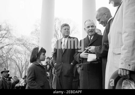 Empfang für Astronaut John Herschel Glenn, Jr., 11:55am Uhr. Ingenieur-Kommissar des Distrikts von Columbia Brigadier General Frederick J. Clarke (Dritter von rechts) überreicht Astronaut Oberstleutnant John H. Glenn, Jr. (zweiter von rechts) bei einem Empfang zu Ehren Oberstleutnant Glenn einen Schlüssel zur Stadt. Blick auf (L-R): Präsident John F. Kennedyu0027s Nichte Maria Shriver (im Profil), Präsident Kennedy, und Vizepräsident Lyndon B. Johnson (teilweise versteckt am Rand des Bildes, mit Hut). North Portico, White House, Washington, D.C. Stockfoto