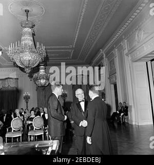 Abendessen zu Ehren des ehemaligen Präsidenten Harry S. Truman (HST), 8:00pm Uhr. Abendessen zu Ehren des ehemaligen Präsidenten Harry S. Truman. (L-R) Präsident John F. Kennedy steht mit Präsident Truman und dem Pianisten Eugene List zusammen. Ebenfalls auf dem Foto enthalten ist Roberta Vinson (zweite Reihe, dunkles Haar). East Room, White House, Washington, D.C. Stockfoto