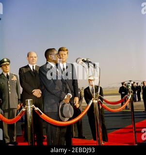 Ankunftszeremonie für William Vacanarat Shadrach Tubman, Präsident von Liberia, 10:00 UHR. Ankunftszeremonien für William V.S. Tubman, Präsident von Liberia. Auf Plattform, erste Reihe (L u2013 R): Präsident Tubman (an Mikrofonen); Präsident John F. Kennedy. Zweite Reihe: Vorsitzender der Generalstabschefs Lyman Lemnitzer; Staatssekretär Dean Rusk. Chef des Protokolls Angier Biddle Duke (rechts von der Plattform). Andrews Air Force Base, Maryland. Stockfoto