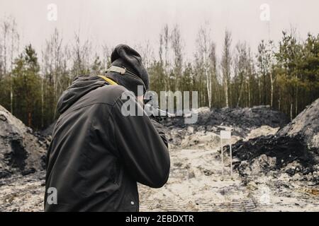 Ein Kerl schießt von einem Jagdgewehr auf die Schießerei Bereich in der Wüste Sportschießen Stockfoto