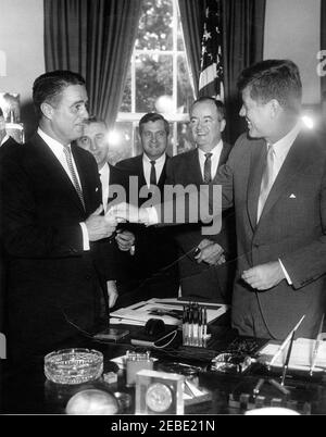 Bill Signing - H.R. 7500 Öffentliches Recht 87-293, Peace Corps Act, 9:45am. Präsident John F. Kennedy reicht dem Direktor des Friedenskorps R. Sargent Shriver nach Unterzeichnung des HR 7500, des Peace Corps Bill, im Oval Office, White House, Washington, D.C. (L-R) Direktor Shriver einen Stift; Vertreter Roman C. Pucinski von Illinois; Vertreter Silvio O. Conte von Massachusetts; Senator Hubert Humphrey von Minnesota; Präsident Kennedy. Stockfoto