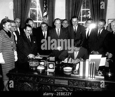 Bill Signing - H.R. 7500 Öffentliches Recht 87-293, Peace Corps Act, 9:45am. Präsident John F. Kennedy unterzeichnet HR 7500, das Peace Corps Bill, im Oval Office, White House, Washington, D.C. mit Blick auf (L-R): Repräsentantin Edna Kelly von New York; Repräsentant Chester Merrow von New Hampshire; Repräsentant Thomas F. Johnson von Maryland; Repräsentant Clement Zablocki von Wisconsin; Vertreter Wayne L. Hays aus Ohio (hinter dem Repräsentanten Zablocki); Vertreter Roman C. Pucinski aus Illinois; Senator Robert S. Kerr aus Oklahoma (hinter dem Repräsentanten Pucinski); Senator Hubert H. Humphrey aus Minne Stockfoto