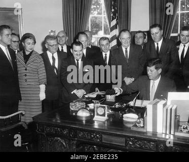 Bill Signing - H.R. 7500 Öffentliches Recht 87-293, Peace Corps Act, 9:45am. Präsident John F. Kennedy unterzeichnet HR 7500, das Peace Corps Bill, im Oval Office, White House, Washington, D.C., mit Blick auf (L-R): Direktor des Peace Corps, R. Sargent Shriver; Senator Philip A. Hart von Michigan; Vertreter Edna Kelly von New York; Vertreter Chester Merrow von New Hampshire; Vertreter Thomas F. Johnson aus Maryland; Vertreter Clement Zablocki aus Wisconsin; Vertreter Wayne L. Hays aus Ohio (hinter dem Vertreter Zablocki); Vertreter Leslie C. Arends aus Illinois (ganz hinten); Vertreter Stockfoto