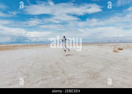 Person springt am Strand - Konzept der Levitation. Windiger Tag Stockfoto