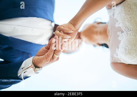 Hochzeitspaar hält oben die Hände POV Stockfoto