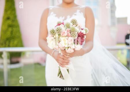 Braut hält EINEN Blumenstrauß Stockfoto