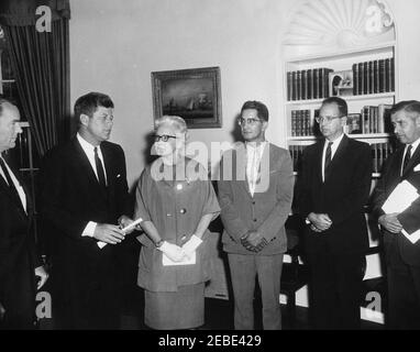 Ankündigung der ersten öffentlichen Wohnungen für Inder, 11:42am. Präsident John F. Kennedy kündigt die erste öffentliche Wohnungsplanung für eine indische (Native American) Reservation, Oval Office, White House, Washington, D.C. Präsident Kennedy gratuliert dem Oglala Sioux Stamm der Pine Ridge Reservation in South Dakota und der Oglala Sioux Housing Authority. (L-R) Stellvertretender Administrator der Housing and Home Finance Agency Jack T. Conway; Präsident Kennedy; Public Housing Commissioner Marie McGuire; Chief Johnson Holy Rock des Oglala Sioux Tribe; Rechtsanwalt des Oglala Sioux Tribe R Stockfoto