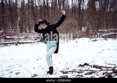 Androgyne Tänzerin in leuchtend blauen Hosen tanzt im Schnee hinein Deutschland Stockfoto