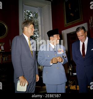 Mittagessen zu Ehren von Sukarno, Präsident Indonesiens, und Modibo Keu00efta, Präsident Malis, 1:10pm Uhr. Präsident John F. Kennedy steht mit Präsident von Indonesien Ahmed Sukarno im Roten Raum, im Weißen Haus, Washington, D.C. unter Außenminister Chester Bowles steht rechts. Stockfoto