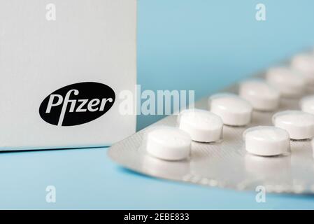 Pfizer Medizin-Box und Blister mit weißen Tabletten auf blau Hintergrund Stockfoto