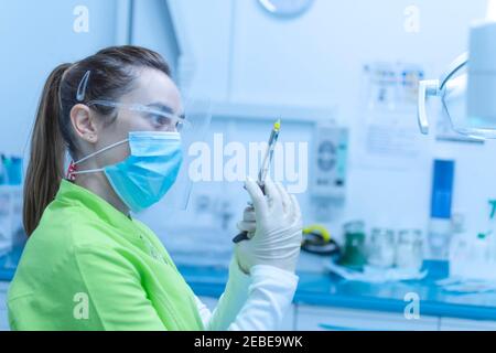 Zahnärztin Vorbereitung der Anästhesie Spritze trägt eine Maske Stockfoto