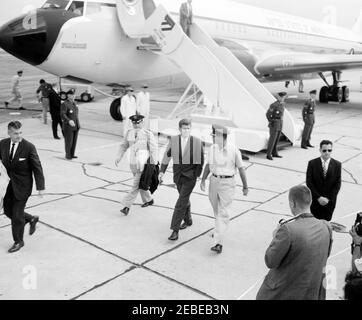 Ankunft am Otis Air Force Base für ein Wochenende im Hyannis Port. Präsident John F. Kennedy geht von Air Force One auf der Otis Air Force Base in Massachusetts weg, begleitet von zwei Mitgliedern der Militärbesatzung. Zu Fuß vor dem Präsidenten ist Secret Service Agent Gerald u201cJerryu201d Behn. [Foto von Harold Sellers] Stockfoto