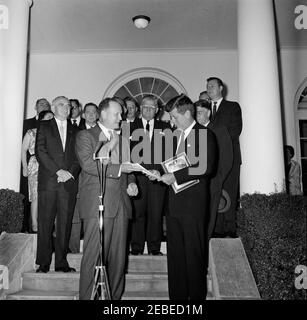 Begrüßungszeremonie nach der Rückkehr der US-Delegation zur Konferenz von Punta del Este in Uruguay, 8:00pm Uhr. Präsident John F. Kennedy betrachtet ein Papier, das ihm vom Finanzminister C. Douglas Dillon auf den Stufen des Rosengartens, des Weißen Hauses, Washington, Präsident Kennedy begrüßte die Delegationsmitglieder zur Interamerikanischen Wirtschafts- und Sozialkonferenz in Punta del Este nach der Rückkehr von delegationu2019s nach Washington. Zu den Personen, die auf der Suche sind: Senator Wayne Morse von Oregon; Vertreter Carl Albert von Oklahoma; Vertreter Armistead Selden von Alabama; Vertreter Stockfoto