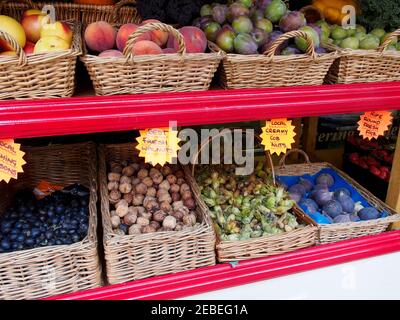 Lokale Produkte zum Verkauf in Rye, Sussex. Frische Walnüsse, Kob-Nüsse und Feigen, sowie Pfirsiche und Pflaumen werden in Körben angezeigt. Stockfoto
