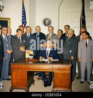 Bill Signing u2013 HR 6874 Öffentliches Recht 8798, NASA (National Aeronautics and Space Administration) Genehmigungen für das Geschäftsjahr 1962, 12:00pm. Präsident John F. Kennedy unterzeichnet HR 6874, National Aeronautics and Space Administration (NASA) Genehmigungen für das Geschäftsjahr 1962. Stehend (L u2013 R): Kongressabgeordneter James G. Fulton (Pennsylvania, meist aus dem Rahmen heraus); Kongressabgeordneter J. Edgar Chenoweth (Colorado); Senator Hubert Humphrey (Minnesota); Senator Warren G. Magnuson (Washington); Vizepräsident Lyndon Johnson (teilweise versteckt); Kongressabgeordneter Joseph E. Karth (Minnesota); Senator Robert S. Kerr (O Stockfoto