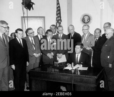 Bill Signing u2013 HR 6874 Öffentliches Recht 8798, NASA (National Aeronautics and Space Administration) Genehmigungen für das Geschäftsjahr 1962, 12:00pm. Präsident John F. Kennedys unterzeichnet HR 6874, National Aeronautics and Space Administration (NASA) Genehmigungen für das Geschäftsjahr 1962. Stehend (L u2013 R): Dr. Robert C. Seamans, Jr., Associate Administrator der NASA; nicht identifiziert (teilweise versteckt); White House Media Network Elektriker, Cleve Ryan (im Rücken); Kongressabgeordneter James G. Fulton (Pennsylvania); Kongressabgeordneter J. Edgar Chenoweth (Colorado); Senator Hubert Humphrey (Minnesota); Senator Warren G. Magn Stockfoto