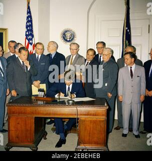 Bill Signing u2013 HR 6874 Öffentliches Recht 8798, NASA (National Aeronautics and Space Administration) Genehmigungen für das Geschäftsjahr 1962, 12:00pm. Präsident John F. Kennedy unterzeichnet HR 6874, National Aeronautics and Space Administration (NASA) Genehmigungen für das Geschäftsjahr 1962. Stehend (L u2013 R): Kongressabgeordneter J. Edgar Chenoweth (Colorado, teilweise aus dem Rahmen heraus); Senator Warren G. Magnuson (Washington); Senator Hubert Humphrey (Minnesota, meist versteckt hinter Senator Magnuson); Vizepräsident Lyndon Johnson (hinten); Kongressabgeordneter Joseph E. Karth (Minnesota); Senator Robert S. Kerr (Oklahoma); C Stockfoto