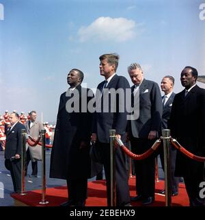 Zeremonie zur Ankunft von Sylvanus Olympio, Präsident von Togo, 11:00am Uhr. Ankunftfeier für den Präsidenten von Togo, Sylvanus Olympio. Auf der Überprüfungsplattform (L-R): Präsident Olympio; Präsident John F. Kennedy; Unterstaatssekretär George Ball; US-Botschafter in Togo, Leon B. Poullada; togolesischer Botschafter in den Vereinigten Staaten, Dr. Andru00e9 Akakpo. Unten links (L-R): Botschafter Nicaraguas und Dekan des Diplomatischen Korps, Dr. Guillermo Sevilla-Sacasa; Staatssekretär für Afrikanische Angelegenheiten, G. Mennen u201cSoapyu201d Williams. US Marine Band steht im Hintergrund. M Stockfoto