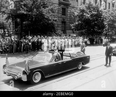 Ankunft Zeremonien für Muhammad Ayub Khan, Präsident Pakistans, 12:00pm Uhr. Autokolonne für Präsident Mohammad Ayub Khan von Pakistan. Im offenen Auto (Lincoln-Mercury Continental Cabrio mit Bubble-Top): Secret Service Agent William Greer (Fahren); Military Aide to the President General Chester V. Clifton (Vordersitz, Mitte); Secret Service Agent Gerald u201cJerryu201d Behn (Vordersitz, rechts; meist versteckt); Präsident Mohammad Ayub Khan (stehend); Präsident John F. Kennedy (stehend). Hinter dem Auto stehen: Geheimagenten Ron Pontius (links) und Roy Kellerman (rechts). Zuschauern zuschauen. 1 Stockfoto