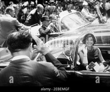 Ankunft Zeremonien für Muhammad Ayub Khan, Präsident Pakistans, 12:00pm Uhr. Ankunft Zeremonien Autokolonne für Präsident Muhammad Ayub Khan von Pakistan. Präsident John F. Kennedy und First Lady Jacqueline Kennedy im Auto (Lincoln-Mercury Continental Cabriolet mit Bubble-Top); nicht identifizierter Mann im Vordergrund (zurück zur Kamera) grüßend der Präsident und First Lady; zweites Auto und Menschenmenge im Hintergrund. Washington, D.C. Stockfoto